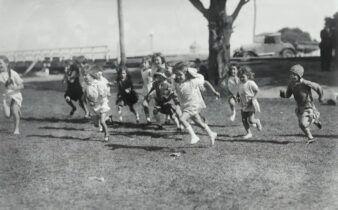 Kinder laufen gemeinsam über eine Wiese – spielerische Leichtathletik