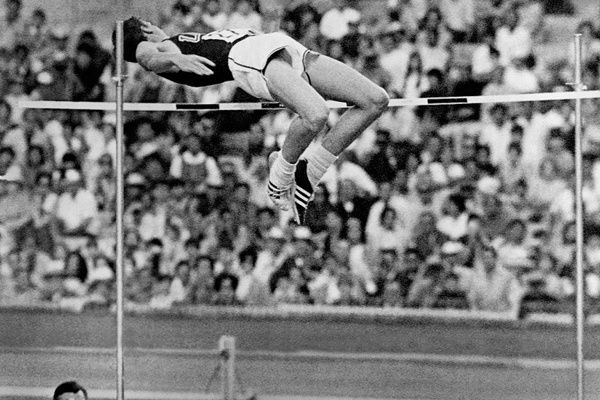 Hochspringer überquert die Latte im charakteristischen Rückwärtsbogen des Fosbury-Flops